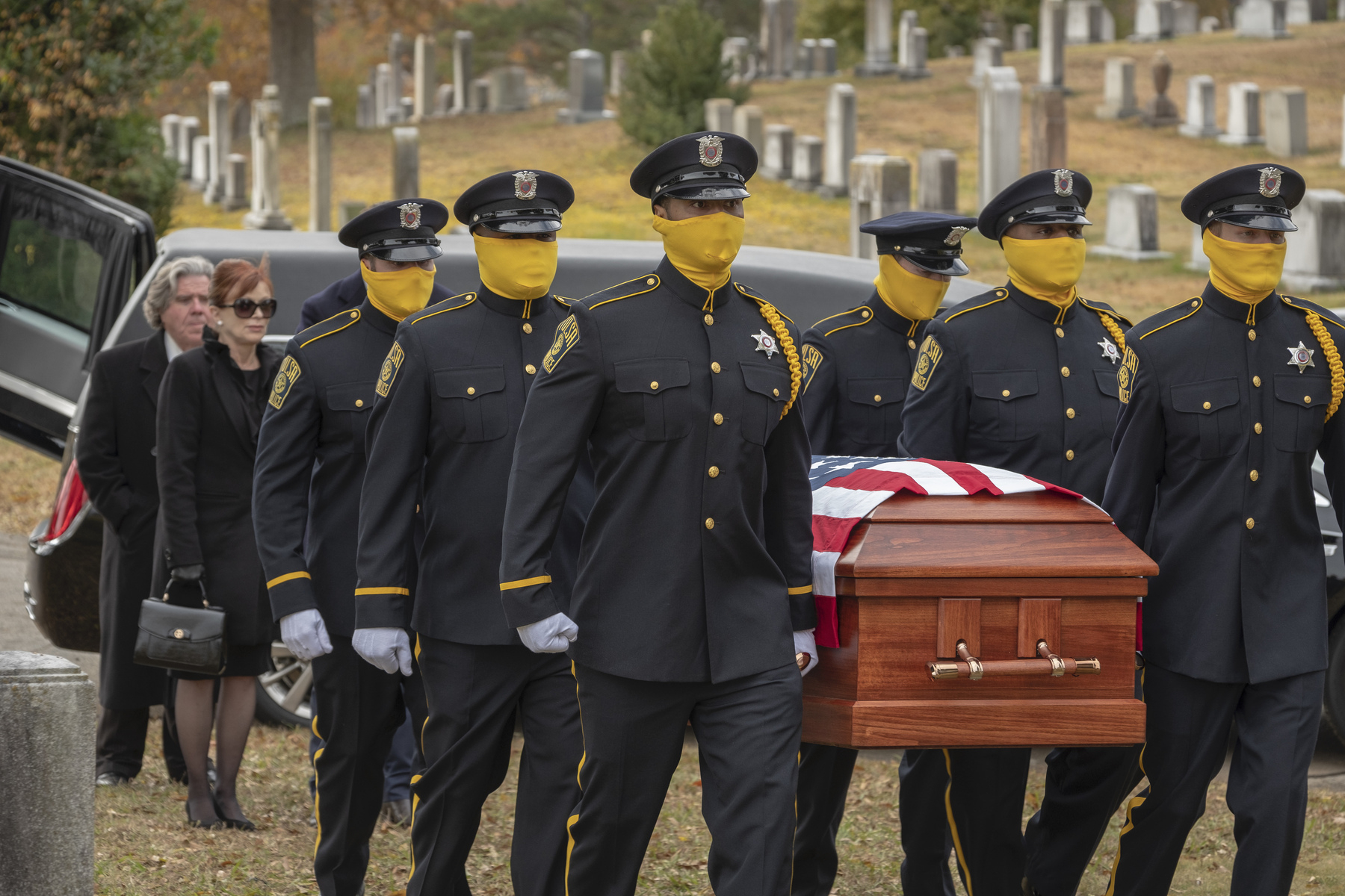 masked cops carrying a coffin