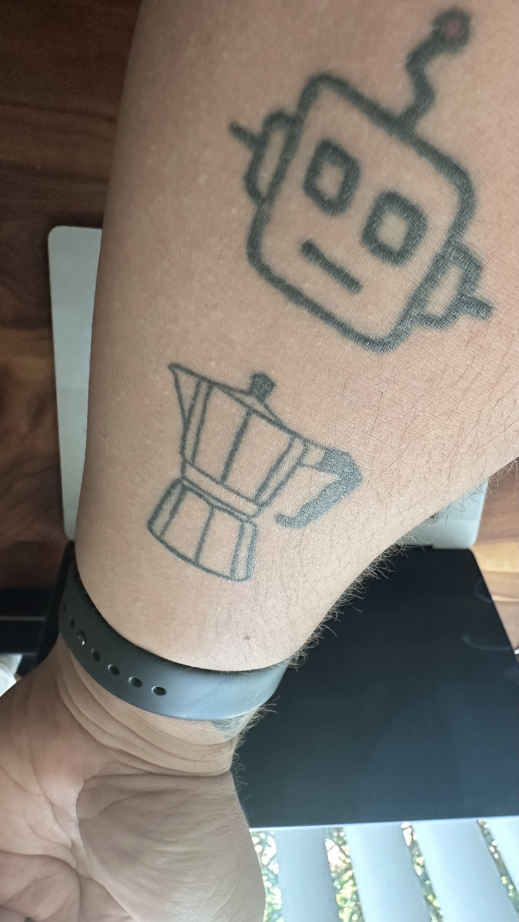 My forearm with a moka pot outline tattoo and a robot tattoo. 