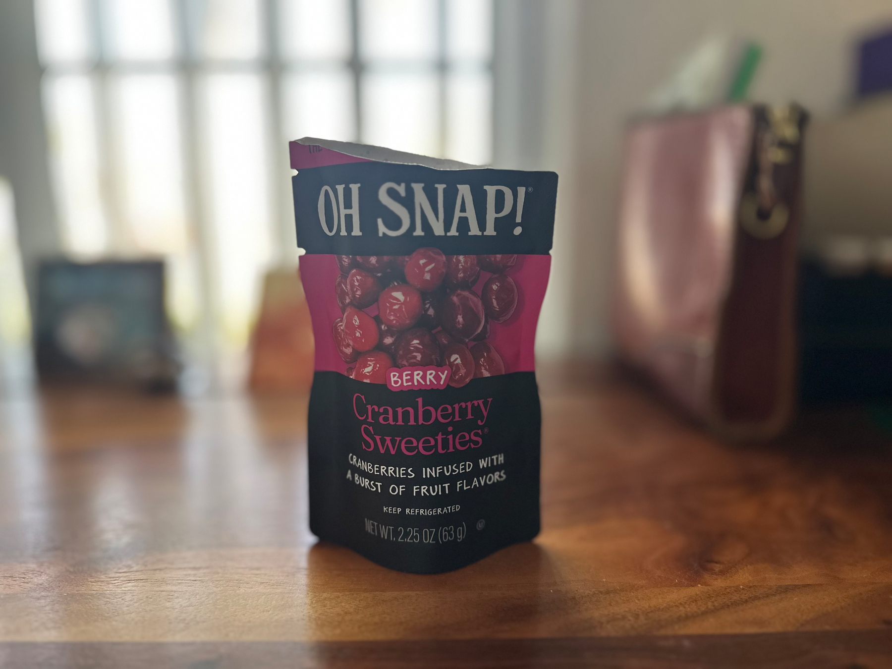 Small black and red bag of "Cranberry Sweeties" on a desk. 