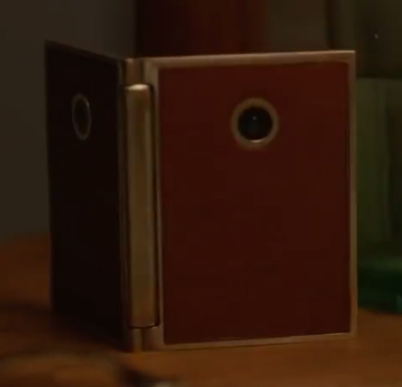 Orange folding device with a hinge. There's a camera on both sides. 