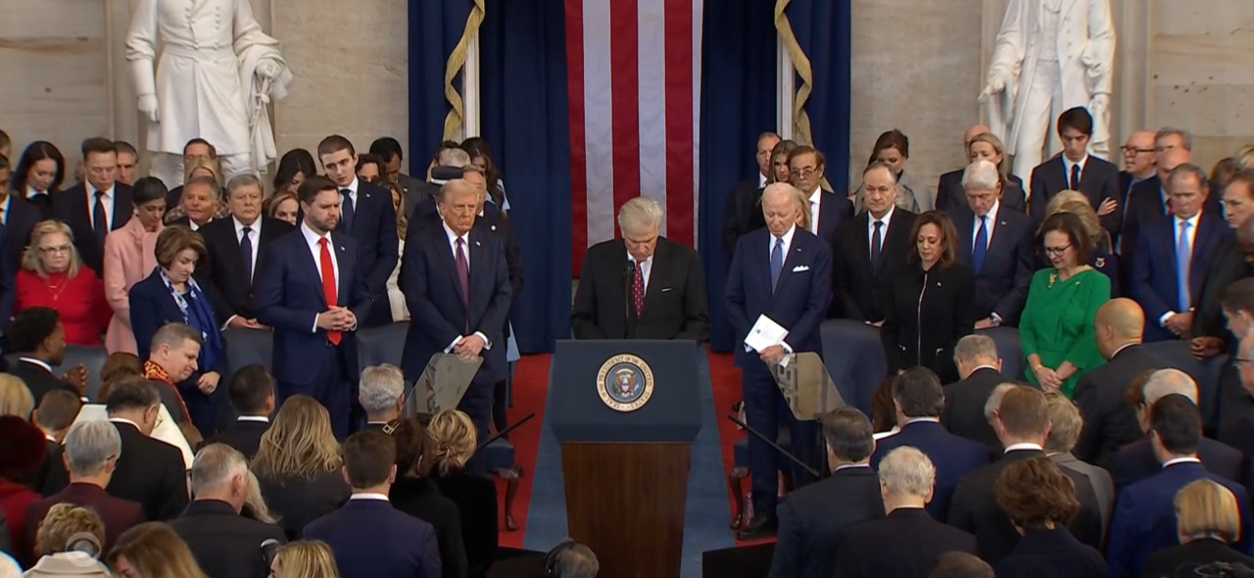 Photo of politicians bowing their heads in prayer. Multiple democrats are present. 