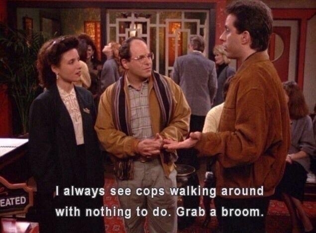 Jerry, Elaine, and George in a restaurant. Jerry says "I always see cops walking around with nothing to do. Grab a broom"