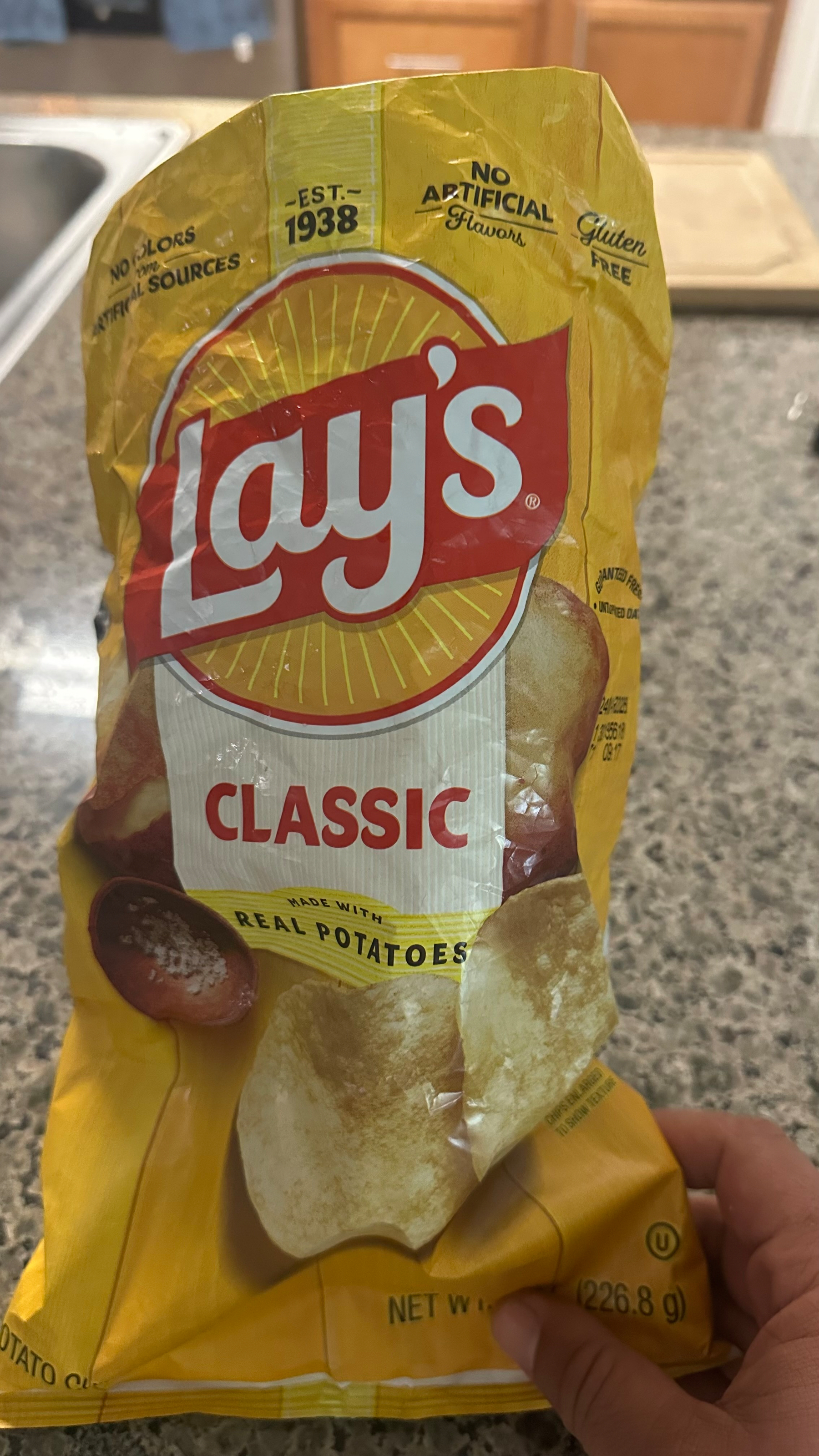 Photo of a bag of Lay's potato chips. The bag is yellow. The Lay's logo is red and white. "Classic". 