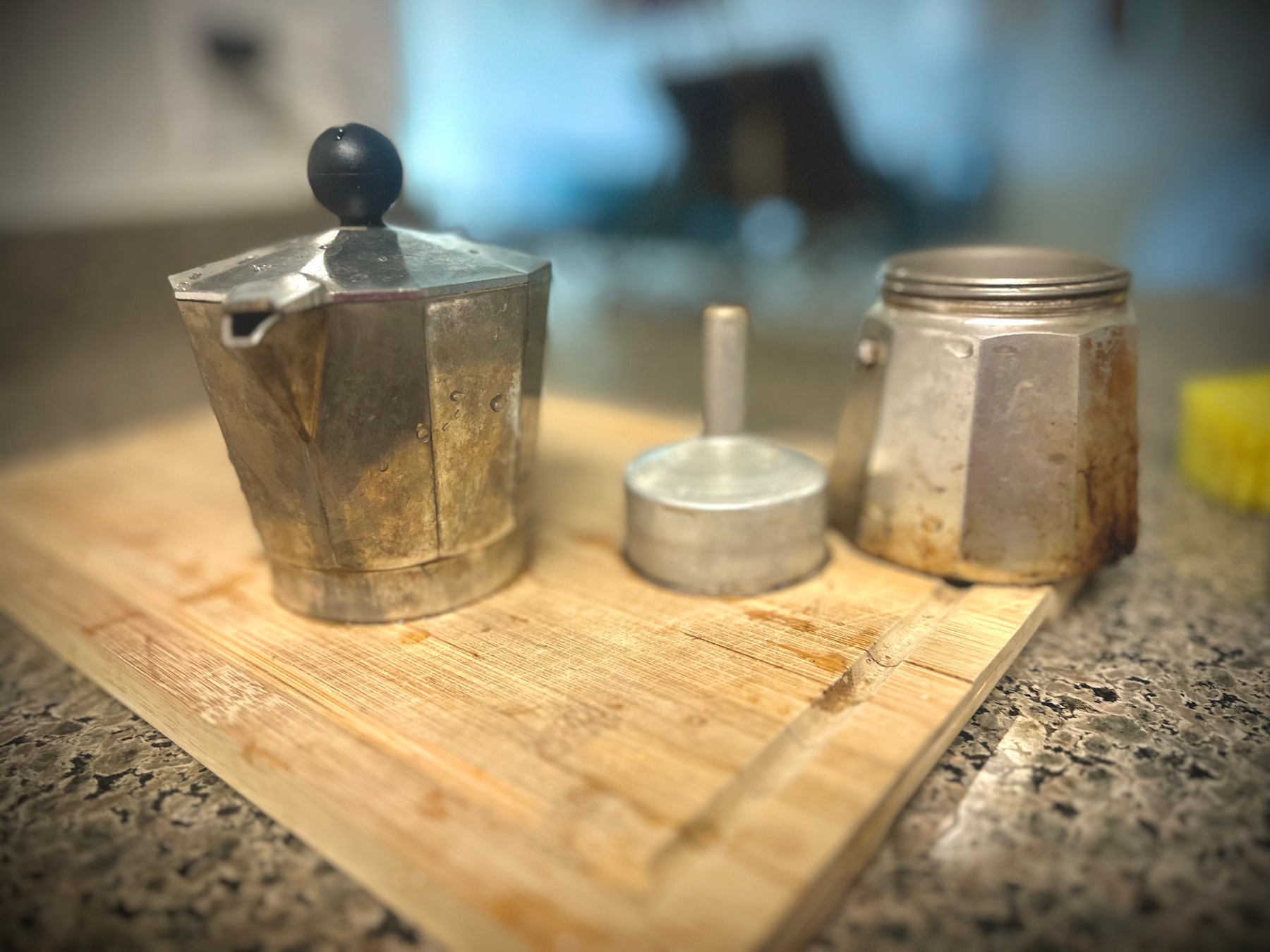 Disassembled mocha pot on top of a cutting board. 