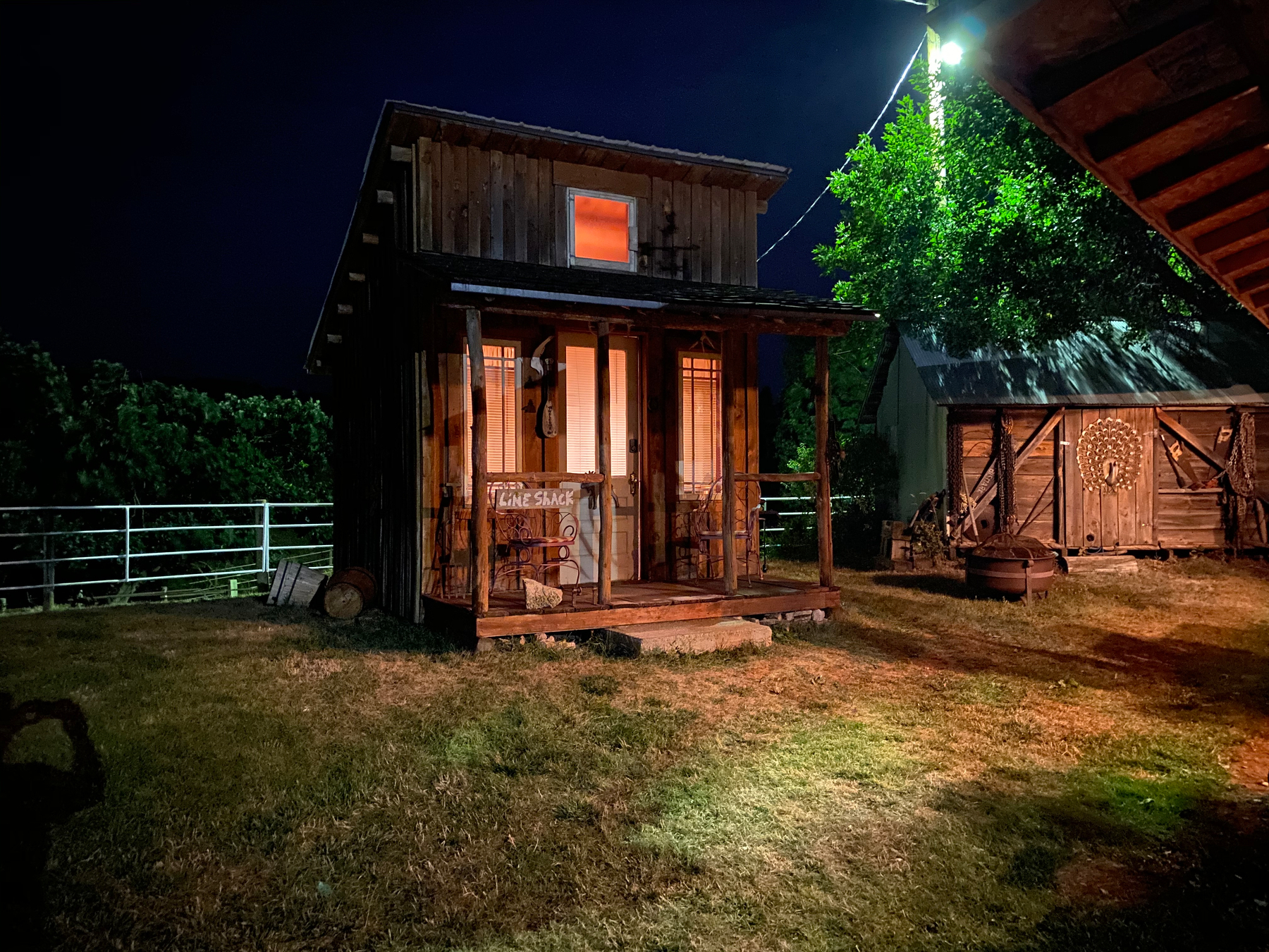 Image of a small outhouse thing. It's nighttime. Looks surreal.