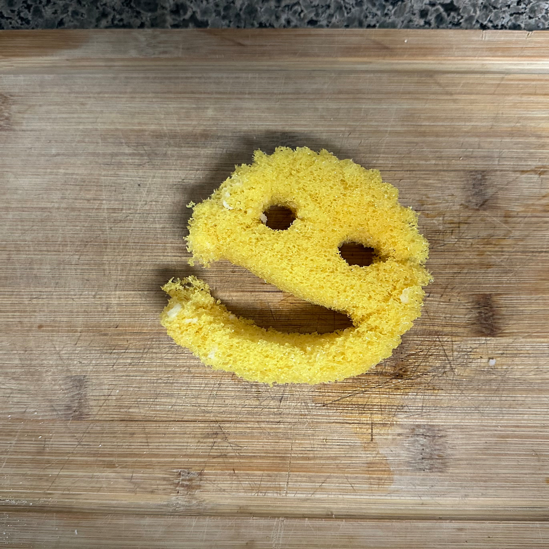 A deteriorated Scrub Daddy on a cutting board  ￼