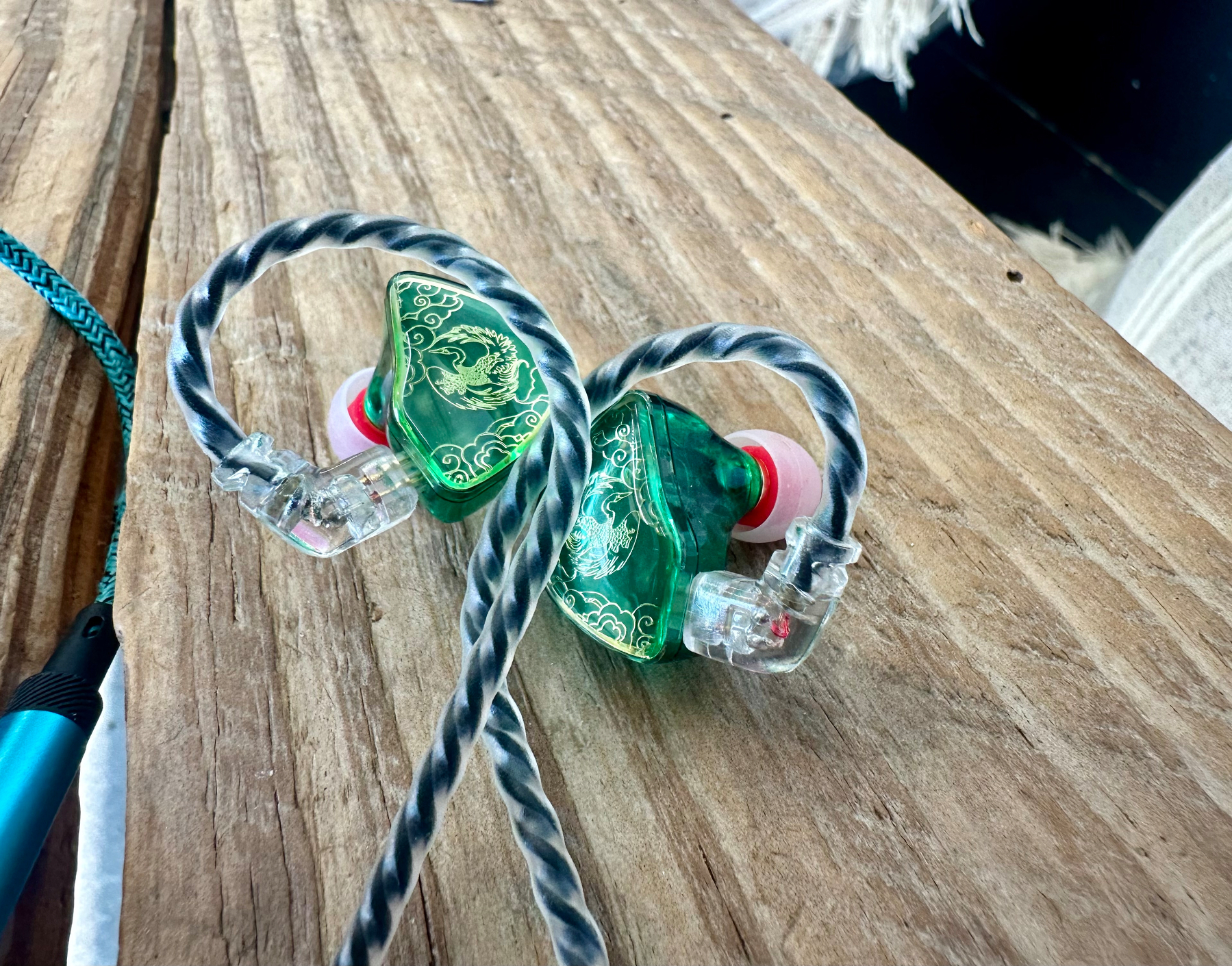 Photo of earbuds. The wires are black and braided. The bud is green with gold ornamentation. I think they're really pretty. 