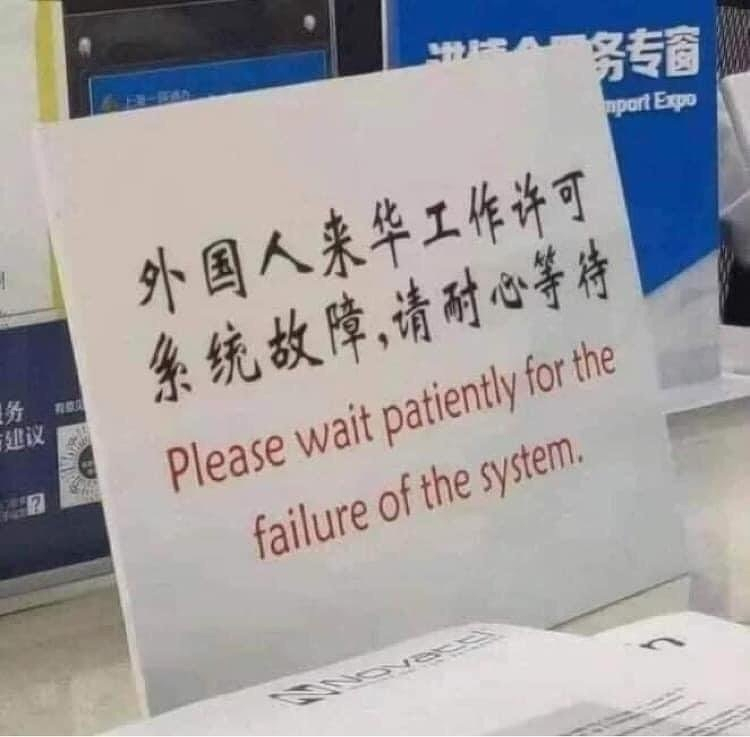 Photo of a sign that says "please wait patiently for the failure of the system" ￼ there are markings from another language, possibly Chinese, but I'm not sure. ￼