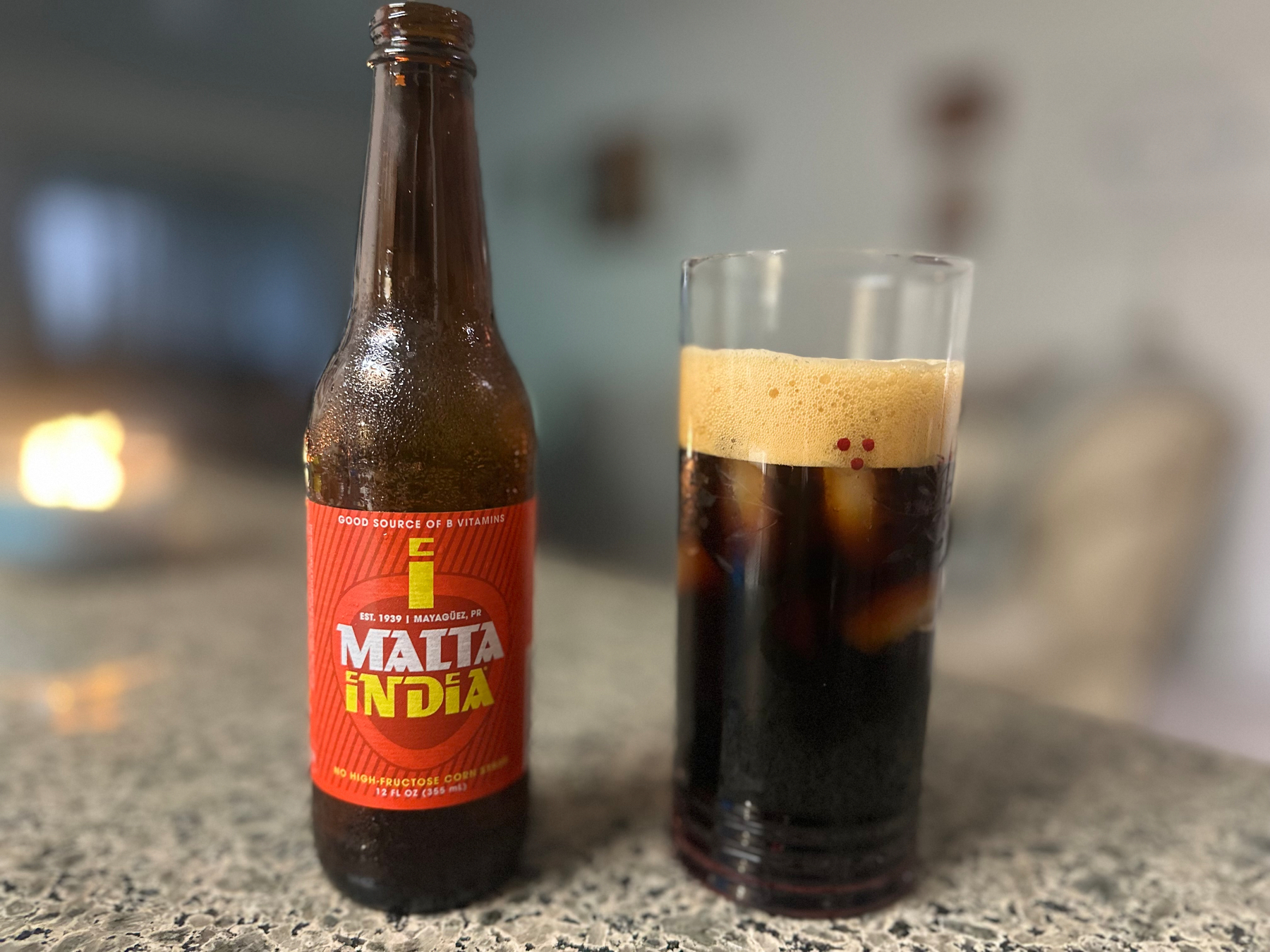 Bottle with red label "Malta India" and a glass with a substance in it that looks a little like Guinness beer. ￼